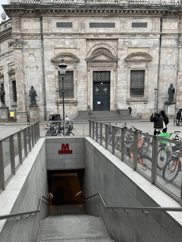 A photograph of a city subway entrance and a classic stone building serves as the real-world base plate