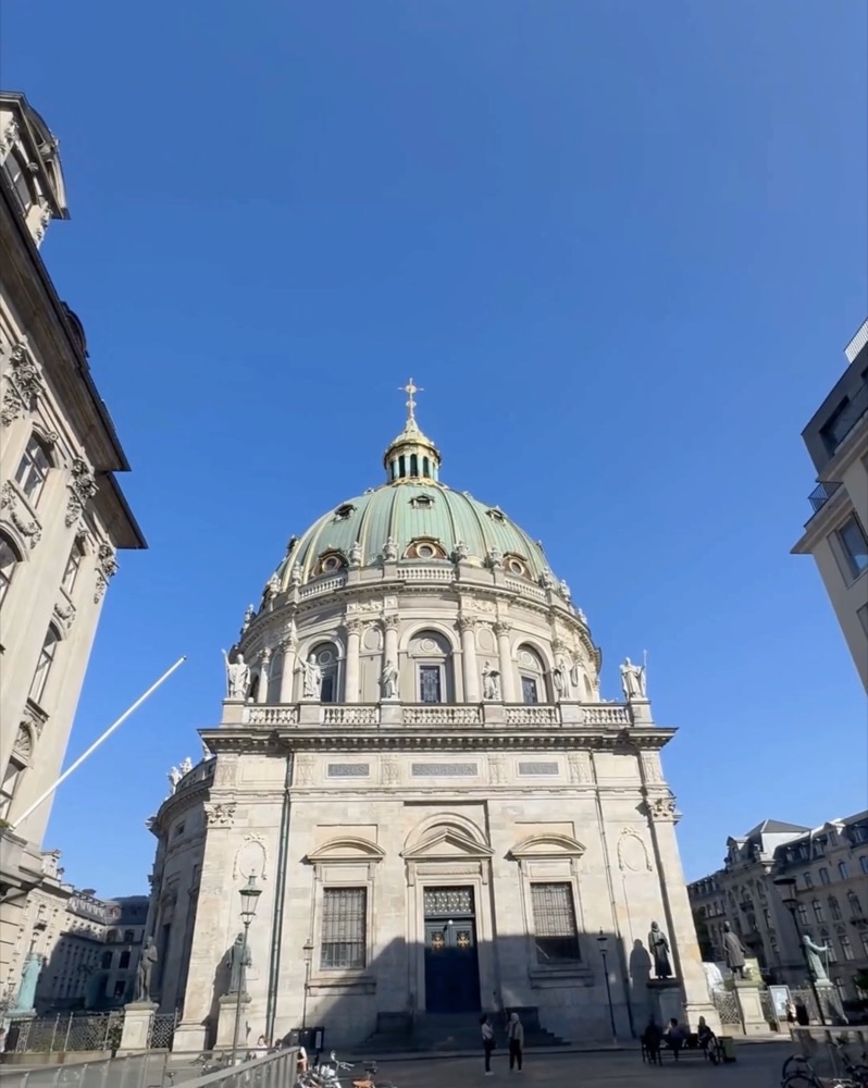 A clean, wide-angle shot captures the "Marble Church" (Frederiks Kirke) in Copenhagen under a clear blue sky