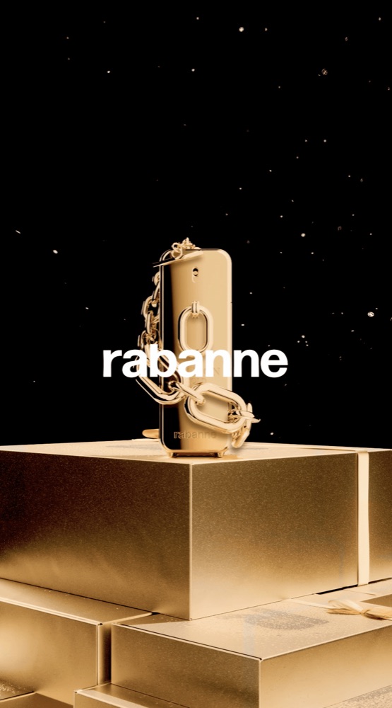 The Rabanne bottle with its signature gold chain stands on a pedestal against a dark, sparkling background